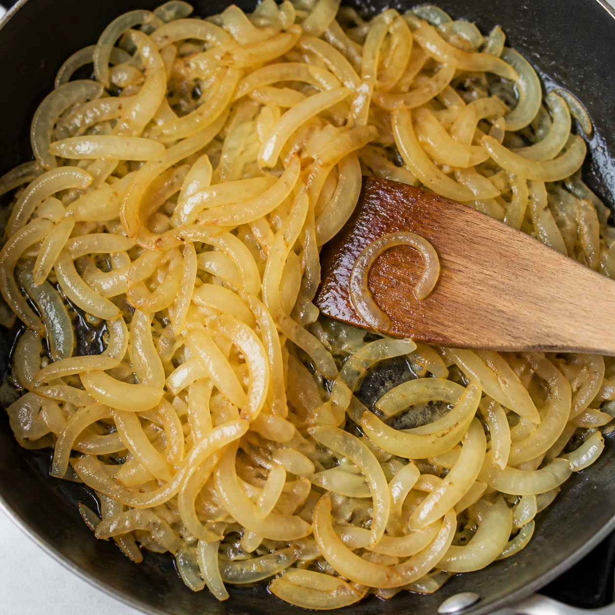 Thinly sliced onions become pale amber in a skillet with a light coating of bacon fat.